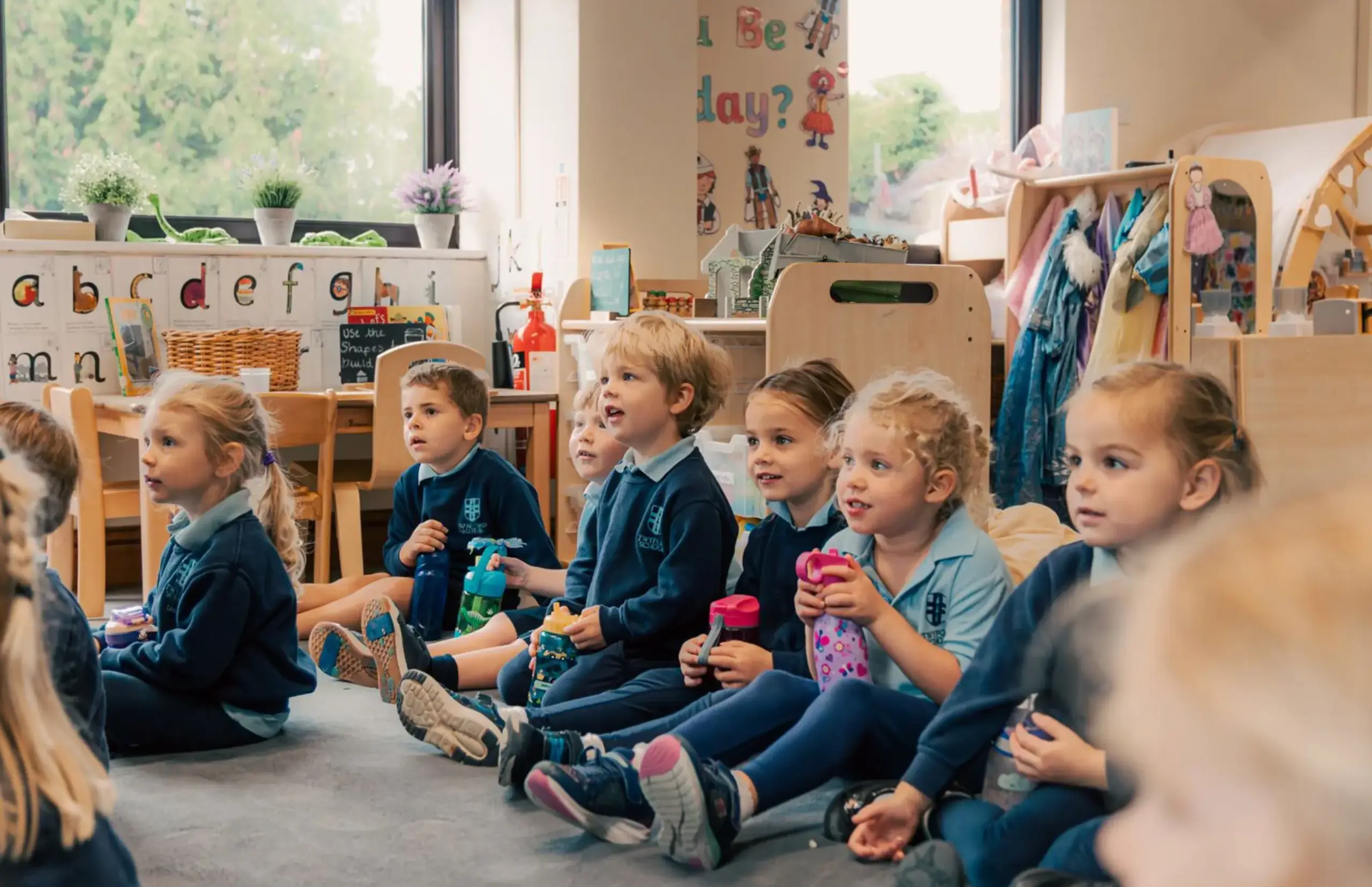 Young children sat on floor in classroom