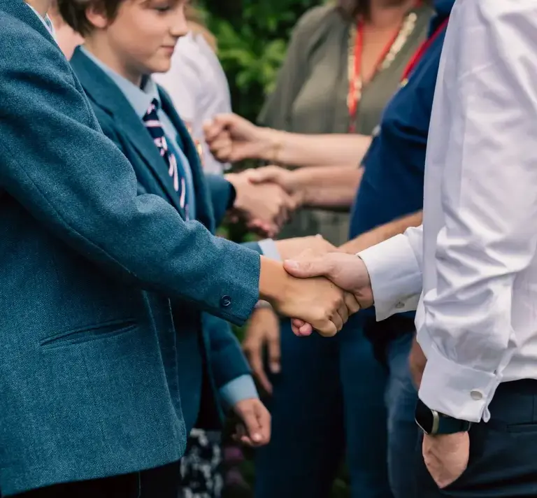 Student and staff shaking hands