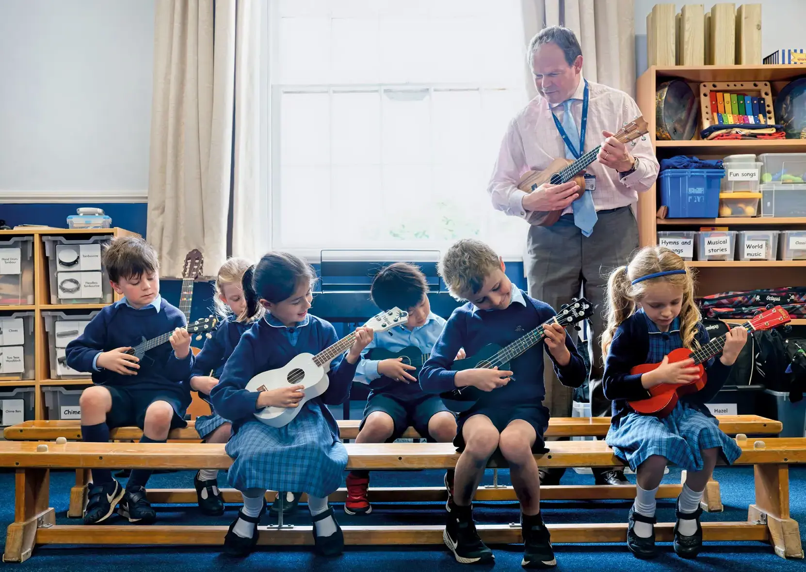 Music teacher playing instruments with class